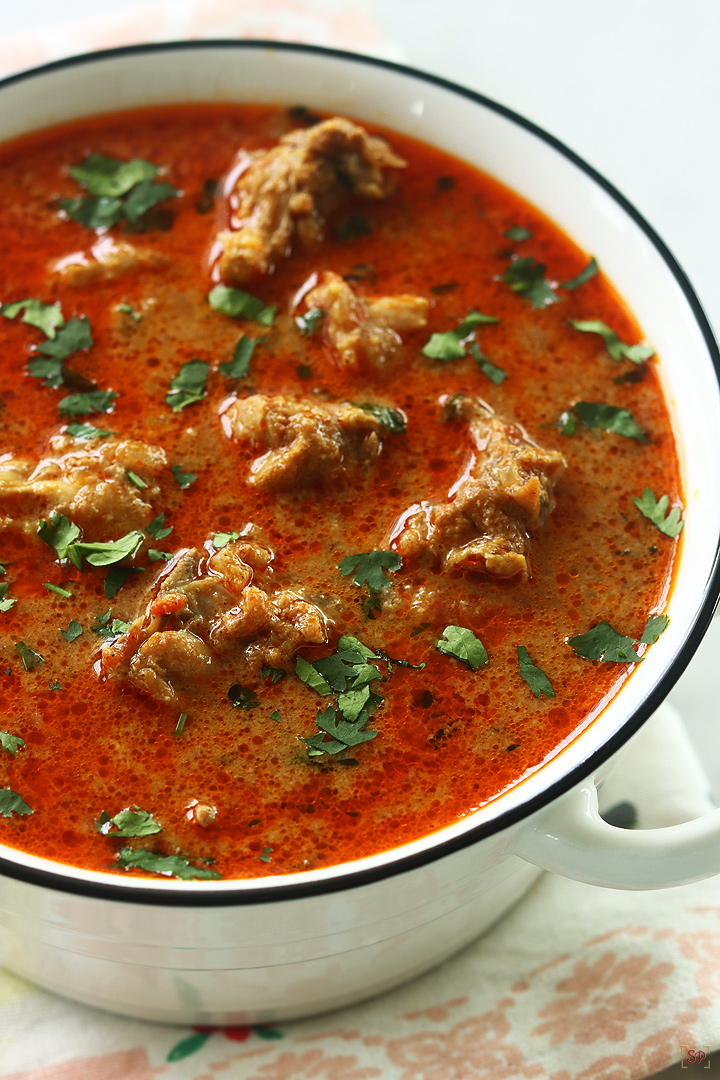 chicken kulambu served in a white bowl