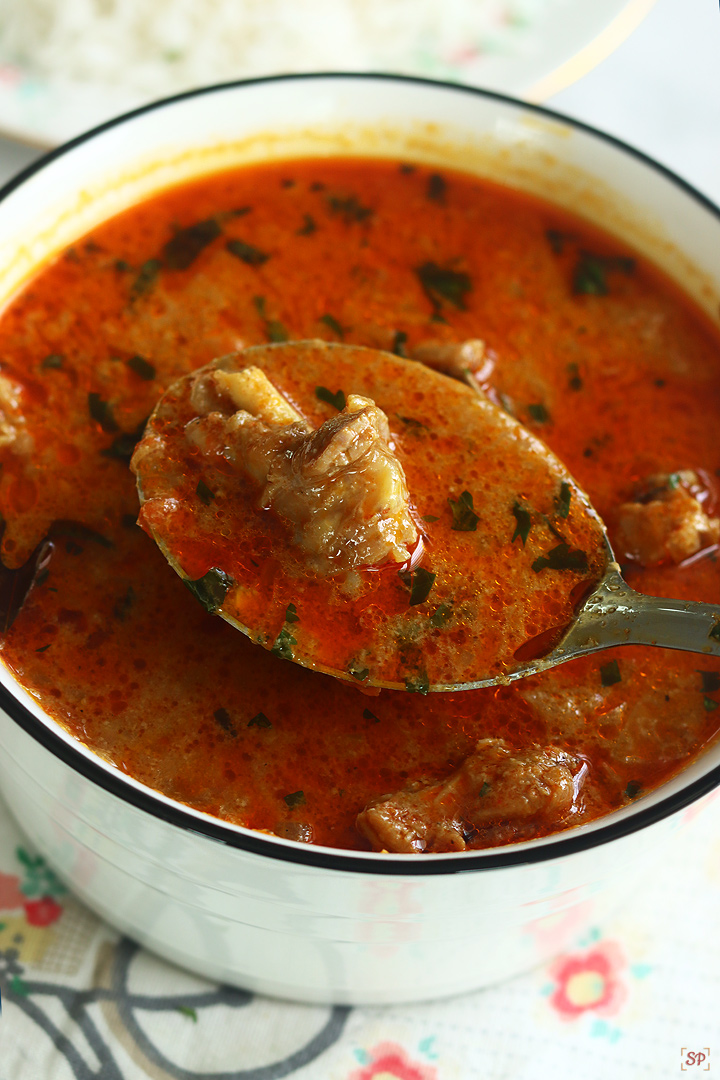 chicken kulambu in a ladle