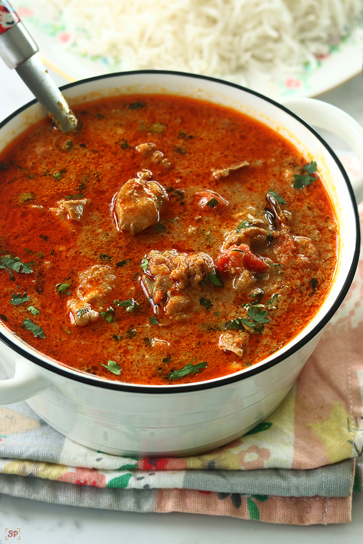 chicken kulambu served in a white bowl