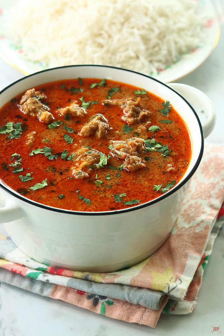 chicken kulambu served in a white bowl