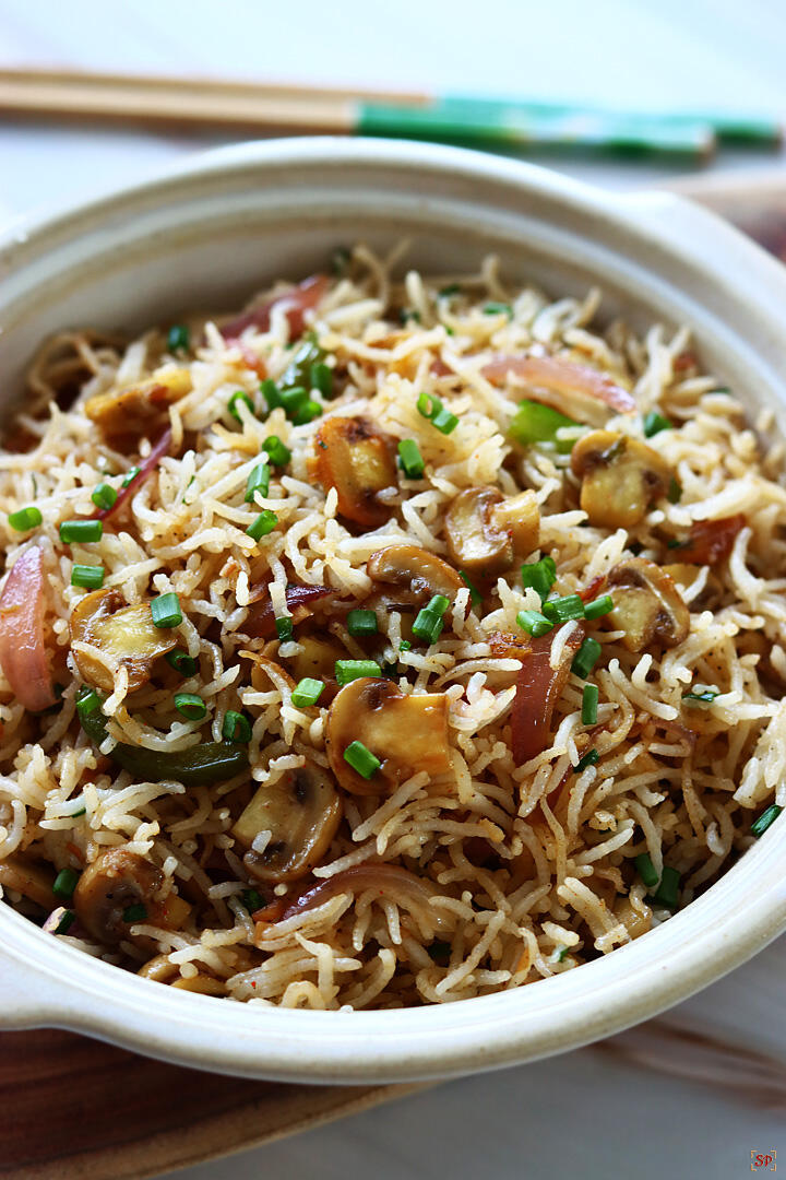 mushroom fried rice served in a bowl with chopsticks on the side