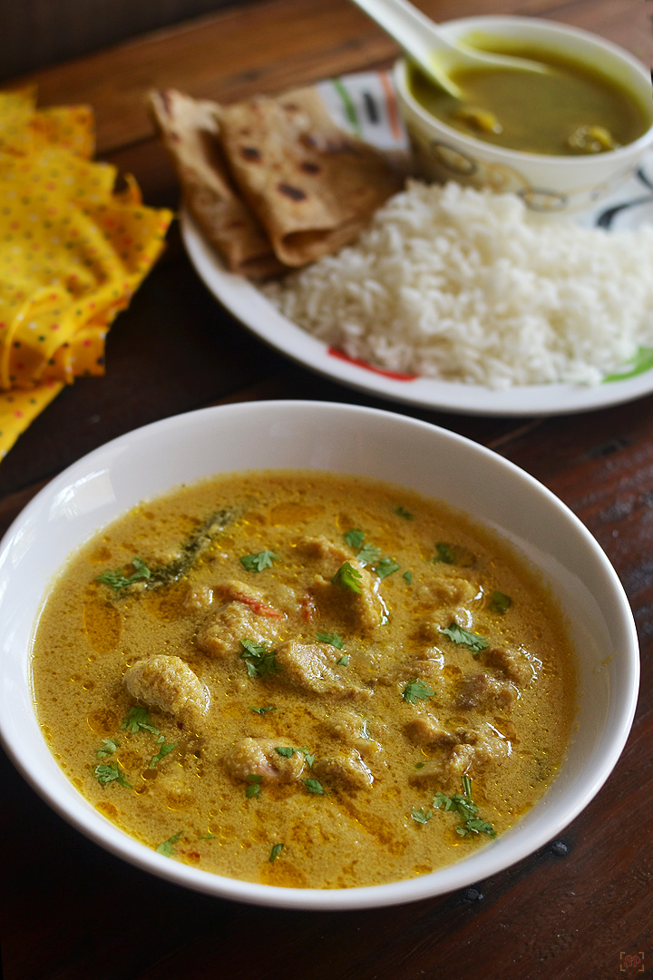 chicken kurma served in a white shallow bowl