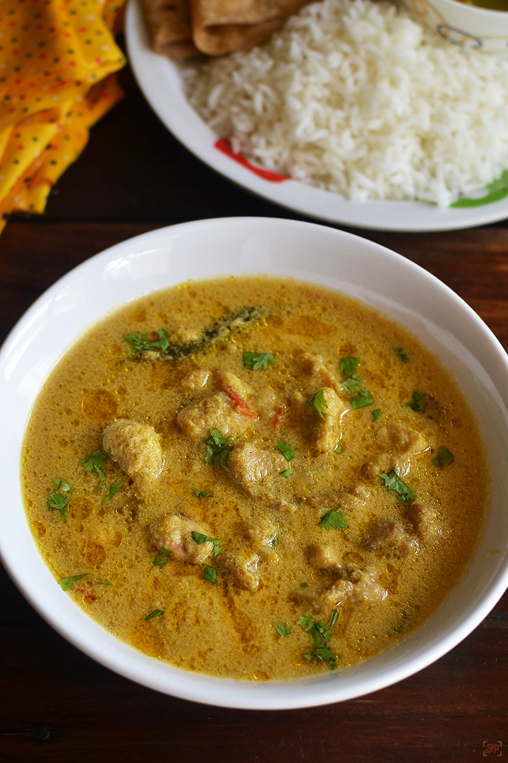 chicken kurma served in a white shallow bowl