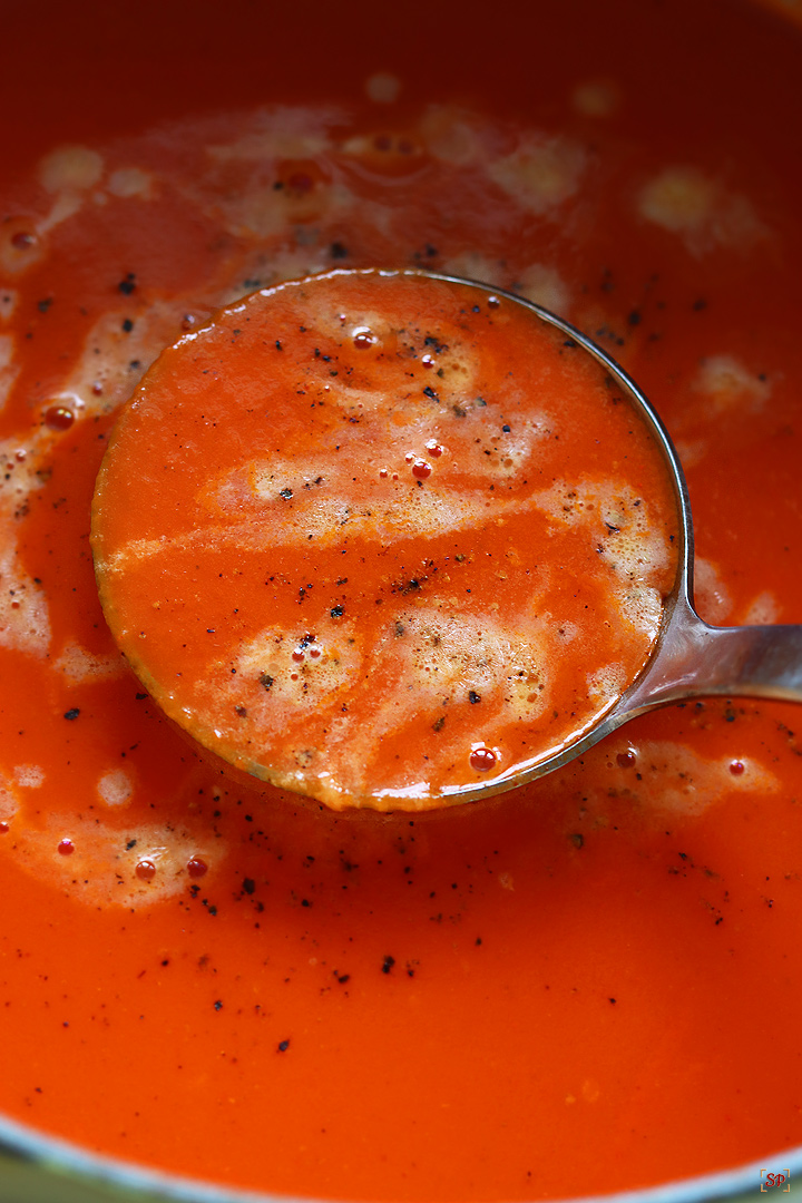 tomato soup in a deep curved ladle