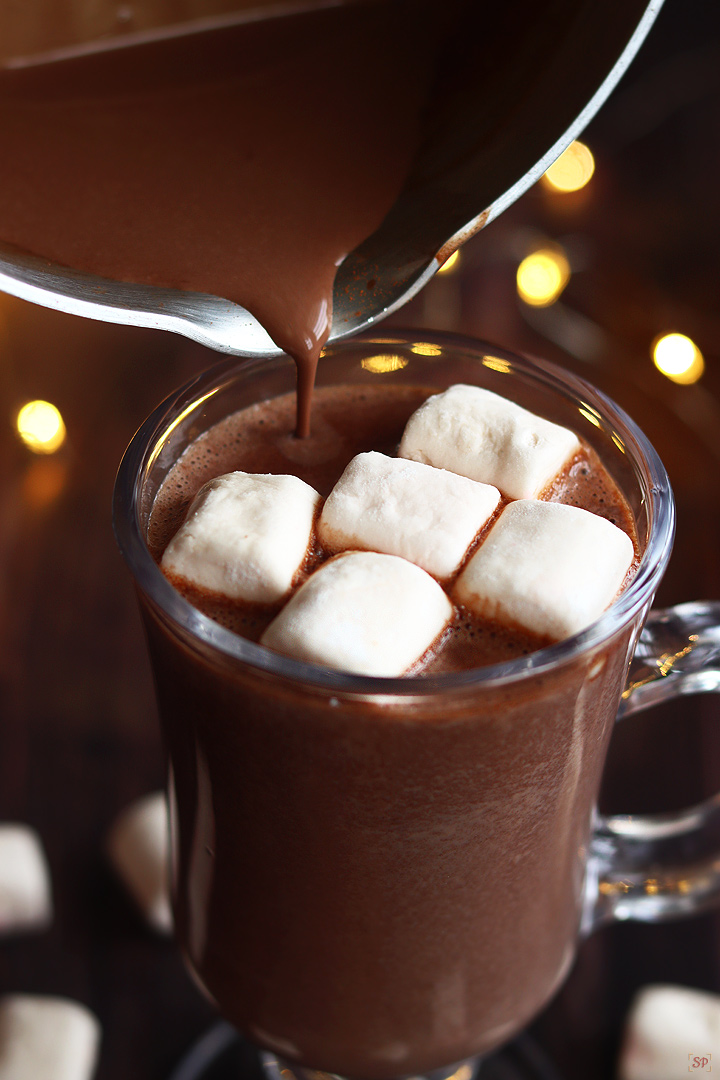 pouring hot cocoa into serving glass