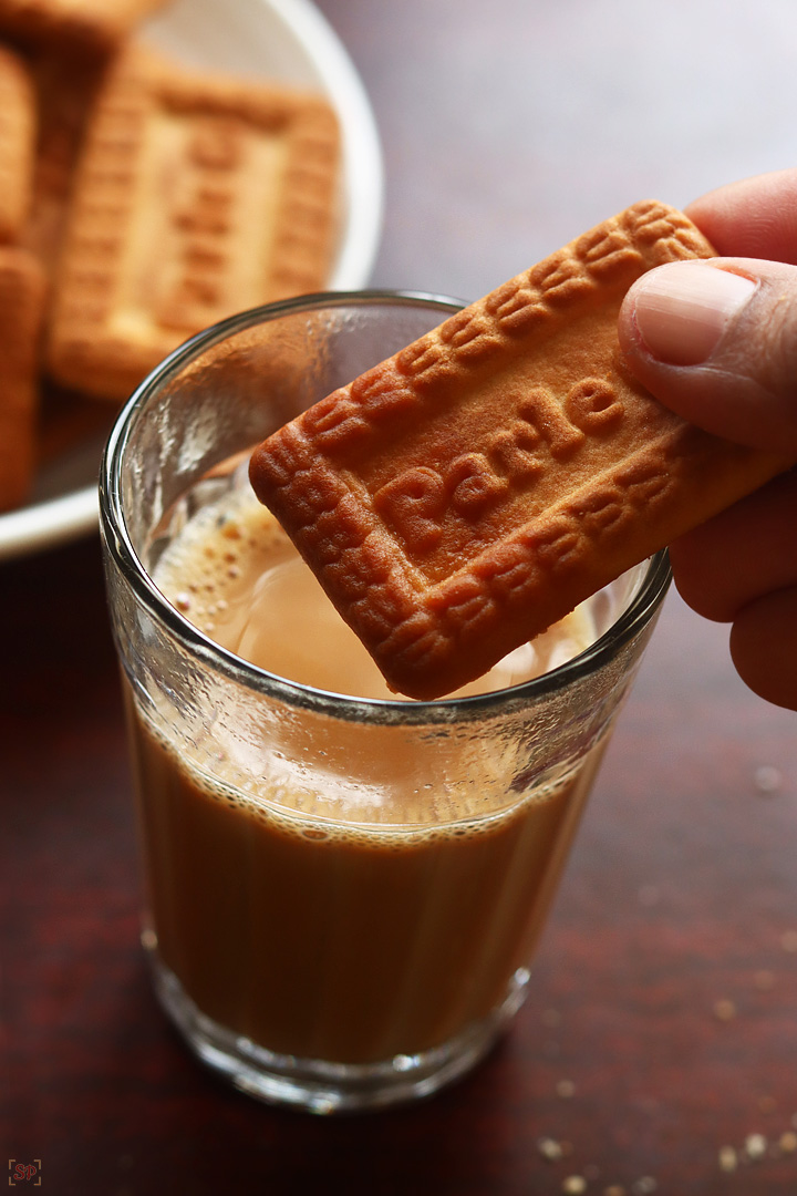 cutting chai served in tea glasses with biscuits