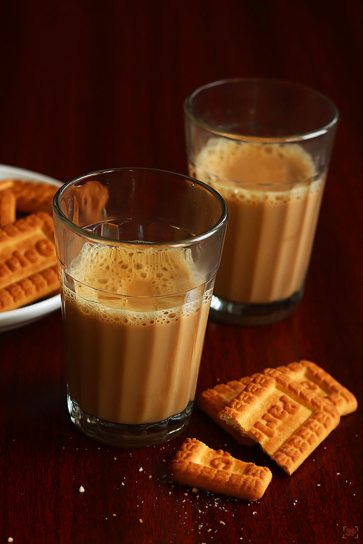 cutting chai served in tea glasses with biscuits