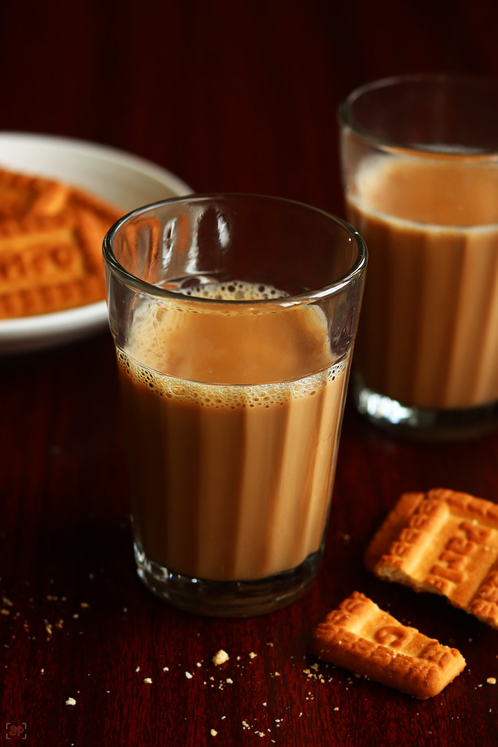 cutting chai served in tea glasses with biscuits